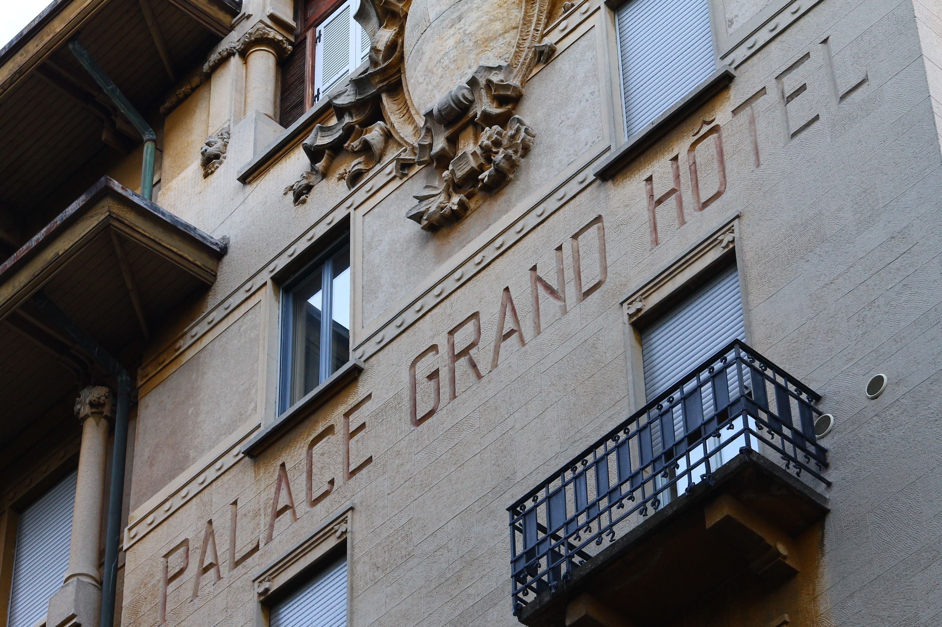 Fachada de edificio con la inscripción "PALACE GRAND HOTEL" y detalles arquitectónicos ornamentales.