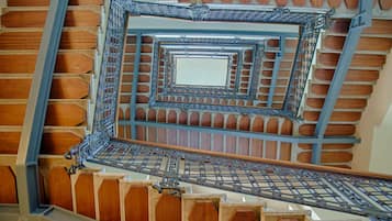 A spiral staircase with a central open space and wooden paneling.