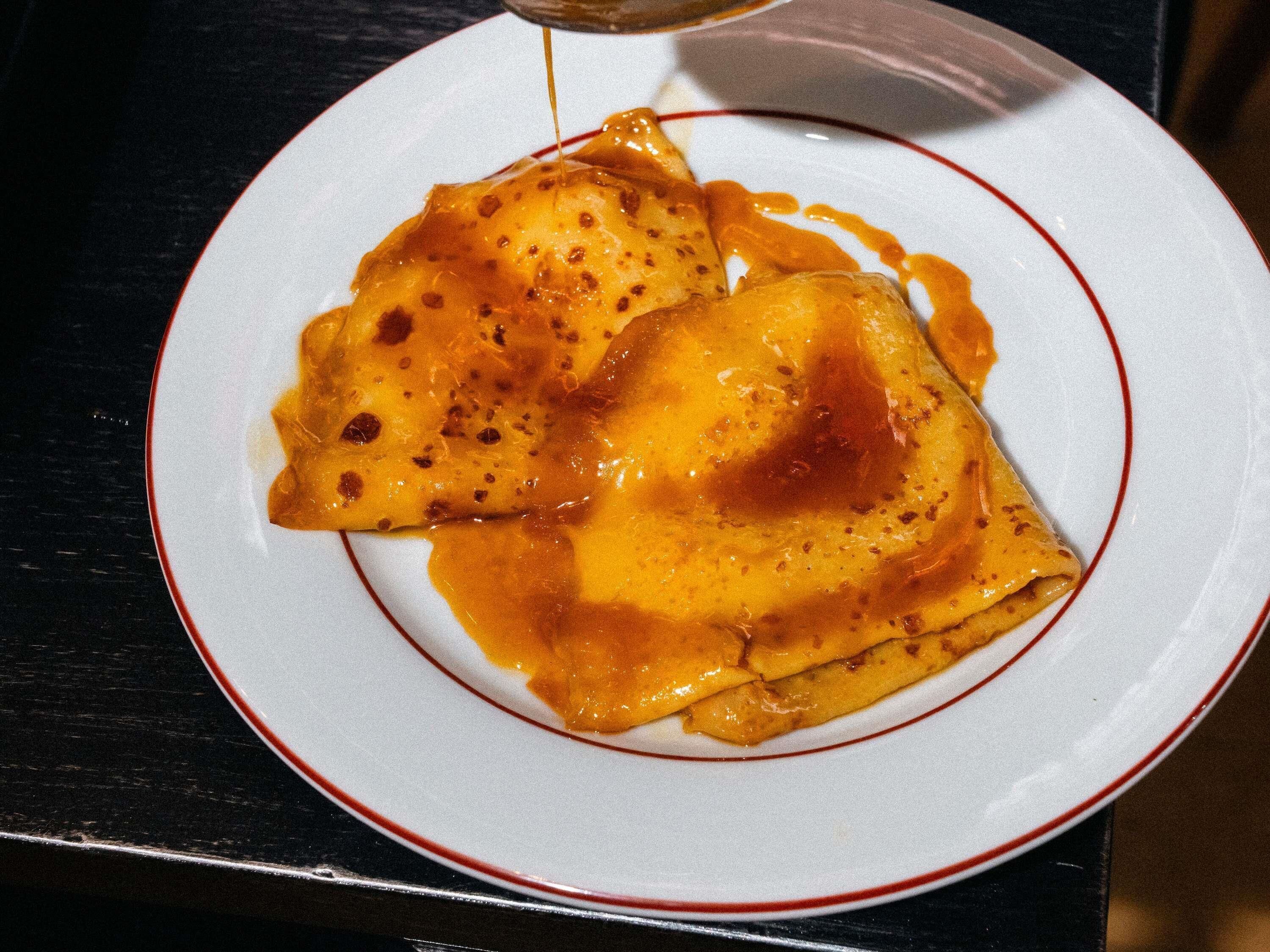 A plate with a food item, possibly a dessert, on a white plate with a red rim.