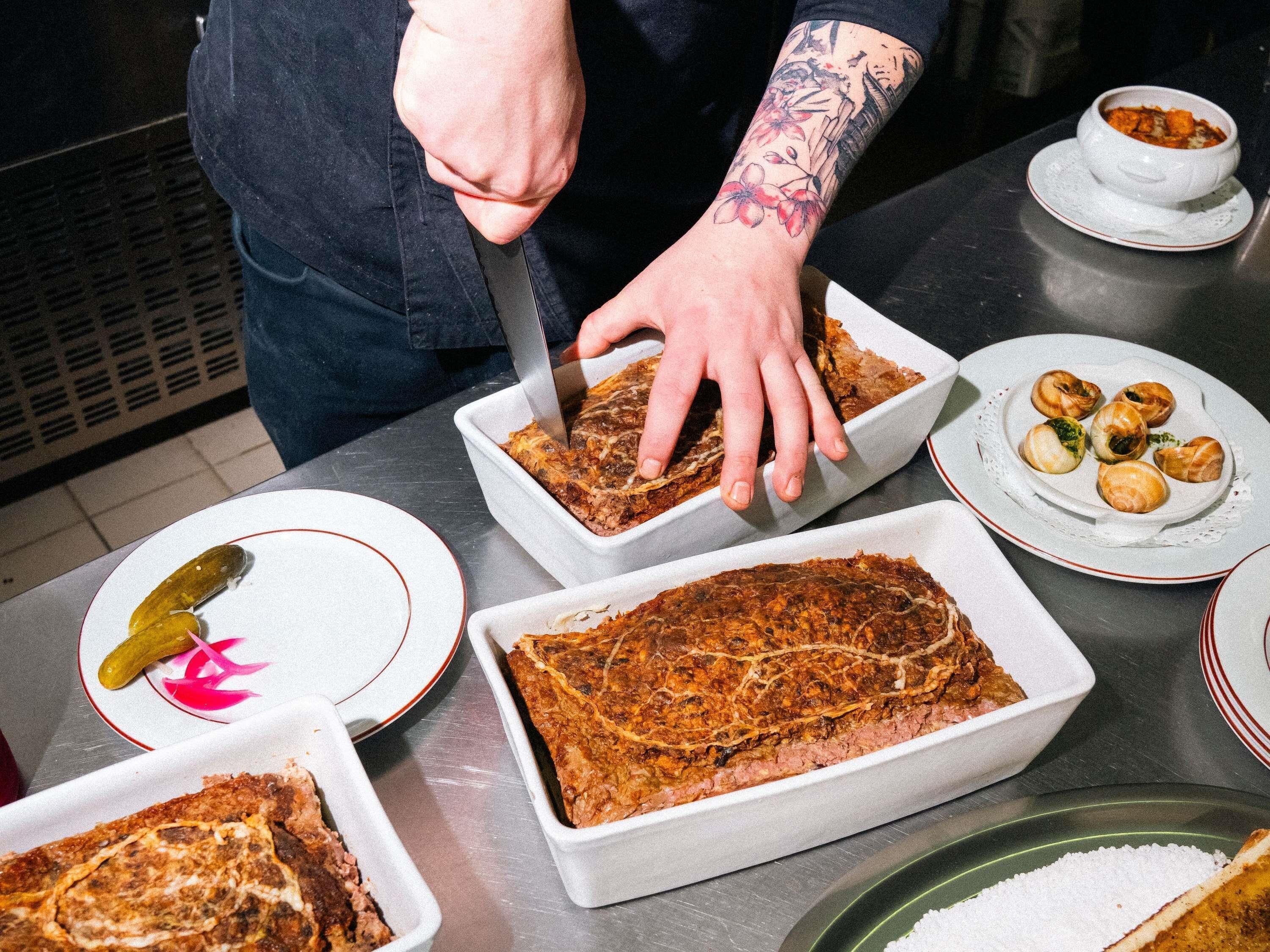 Una persona serve cibo da un vassoio grande, con piatti di cibo e salse ben visibili.