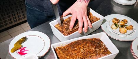 Una persona serve cibo da un vassoio grande, con piatti di cibo e salse ben visibili.