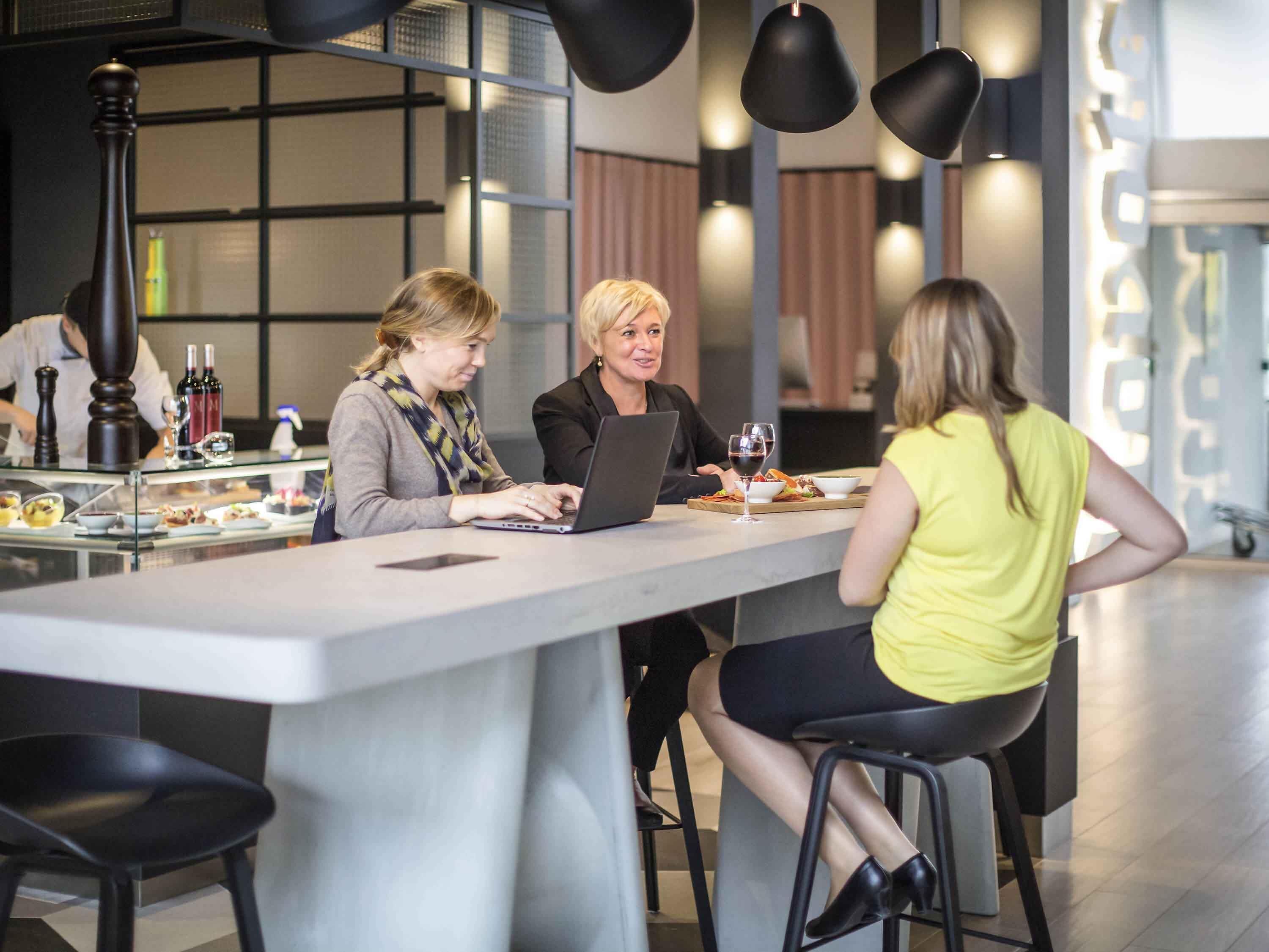 A modern dining area with a central island, bar stools, and pendant lighting.