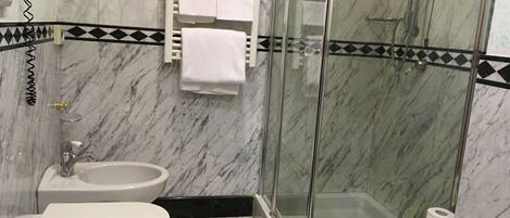 Ein Badezimmer mit Toilette, Bidet und einer Duschkabine.