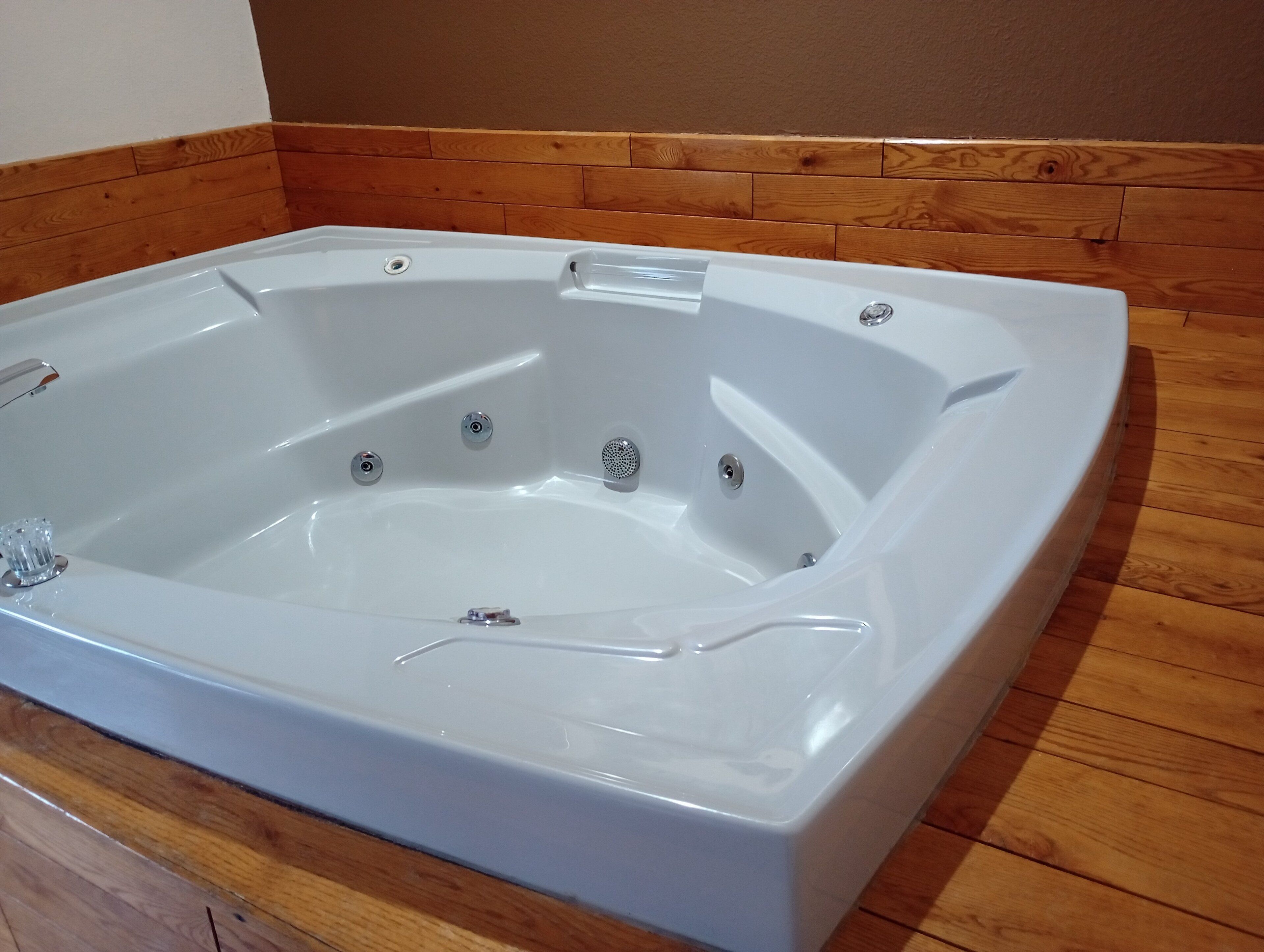 A rectangular hot tub with a wooden floor surrounding it.