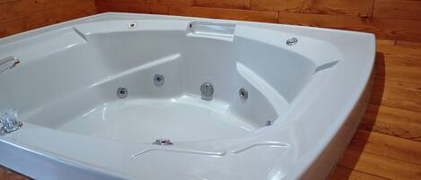 A rectangular hot tub with a wooden floor surrounding it.