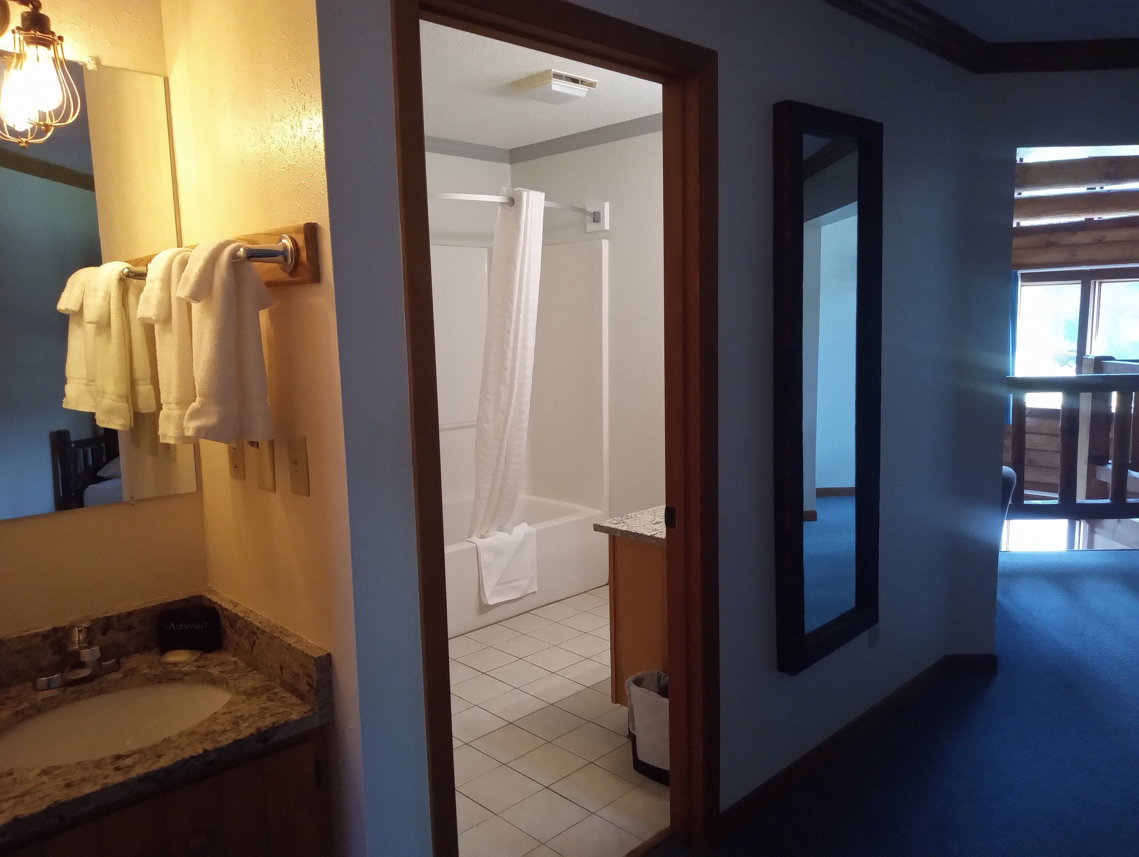 A bathroom with a sink, mirror, and towel rack.