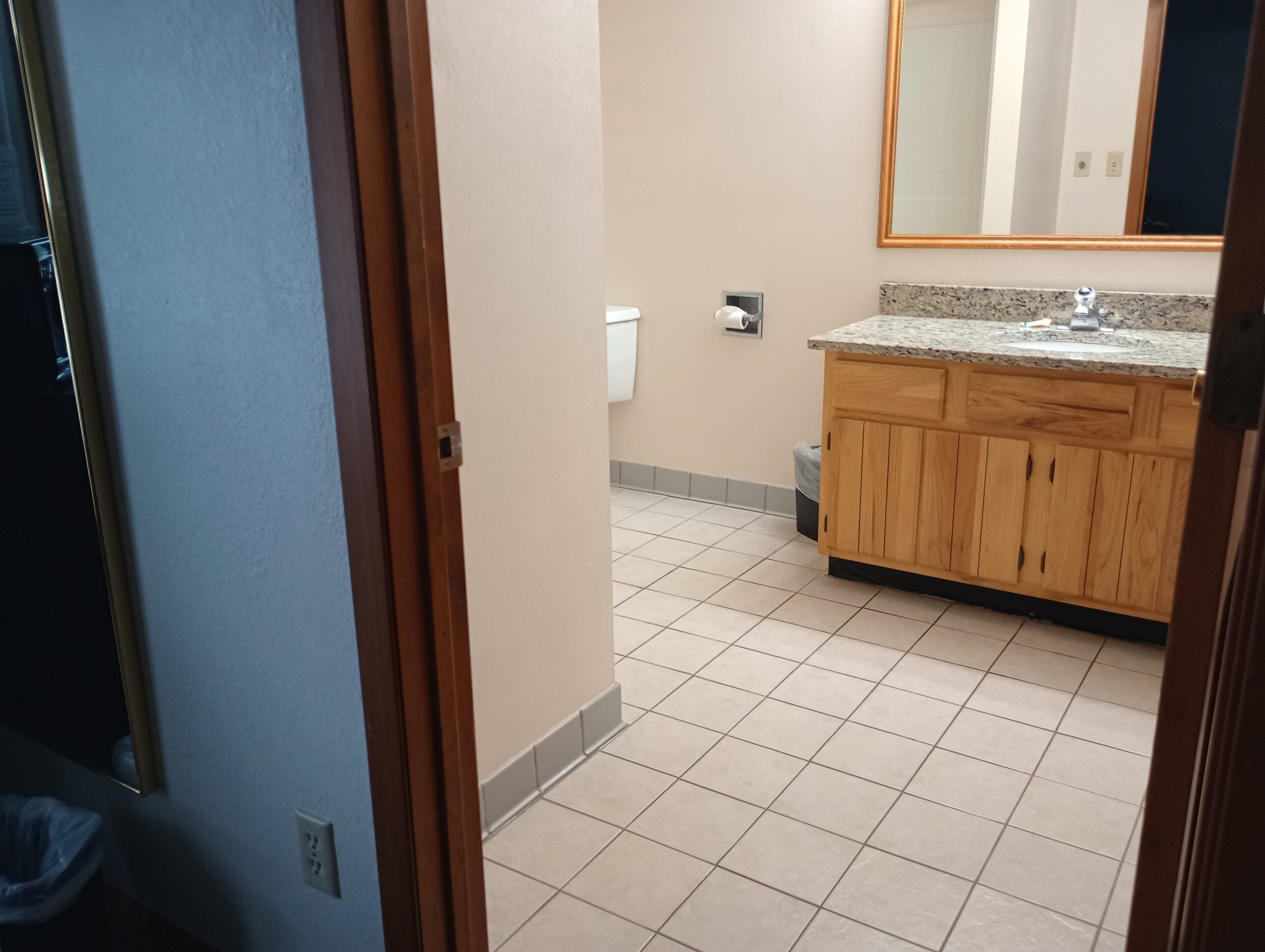 Une salle de bain avec un meuble-lavabo en bois, un évier et un miroir.