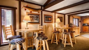 Un interior rústico con muebles de madera, un pez montado en la pared y cuadros enmarcados.