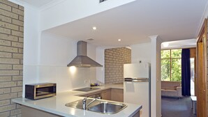 A modern kitchen with a built-in microwave, stainless steel sink, and a large island.