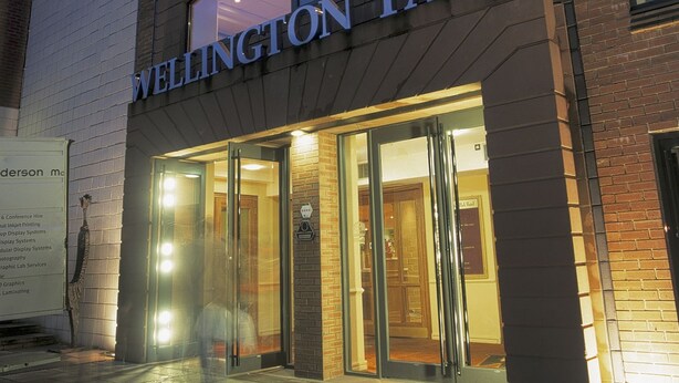 Entrada del edificio Wellington Park con puertas de vidrio y un cartel arriba.