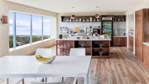 A modern kitchen with a large island, wooden cabinets, and a view of the city. -  Delta Hotel Philadelphia Airport (Philadelphia)