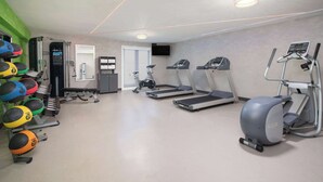 Ein Fitnessraum mit Laufbändern, Crosstrainern und verschiedenen Übungsbällen.