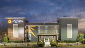 Ein Hotel mit modernem Design, das ein markantes Logo und eine symmetrische Fassade zeigt.