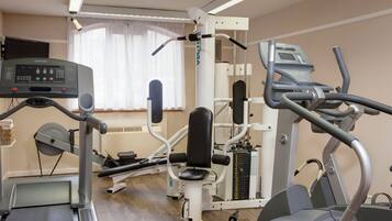 A gym with cardio machines, weight training equipment, and a treadmill.