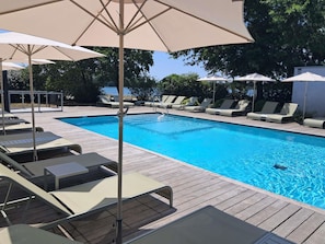 Een seizoensgebonden buitenzwembad en parasols bij het zwembad