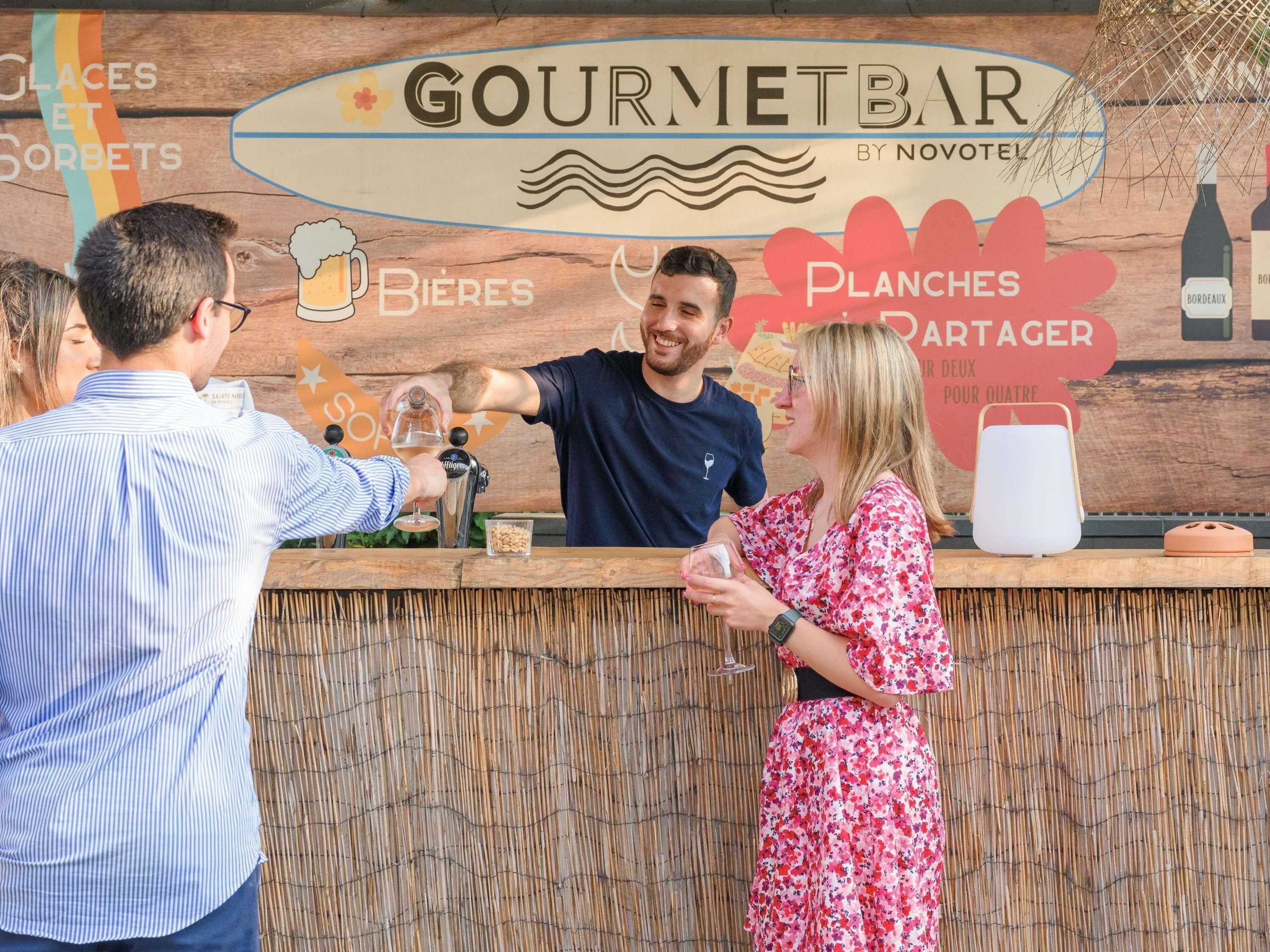 Un espace bar agrémenté d’une enseigne indiquant « Bar gastronomique par Novotel » et « Bières », signalant la vente de bières.