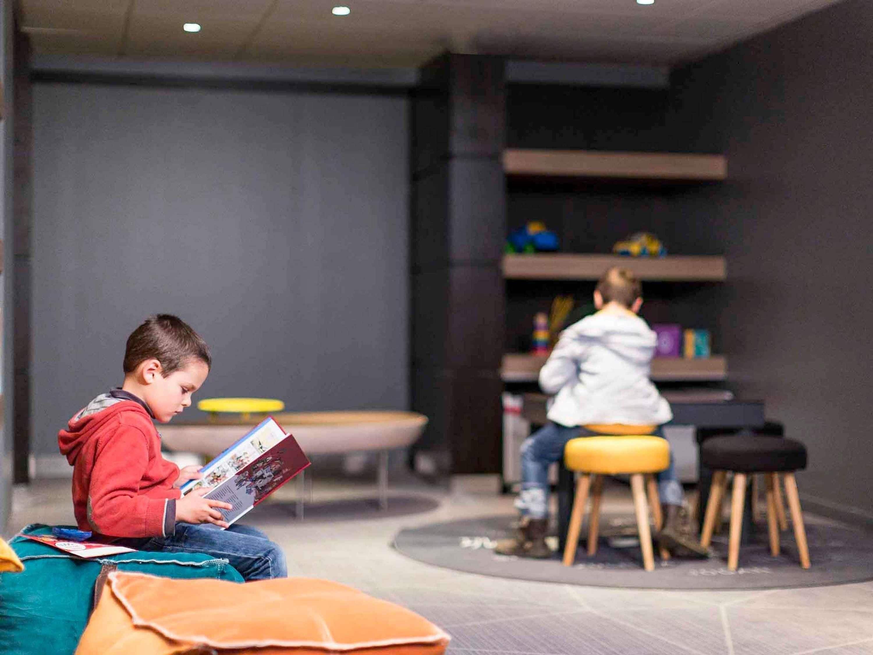 Ein moderner Innenraum mit Sitzbereichen, einem Tisch und einem Bücherregal.