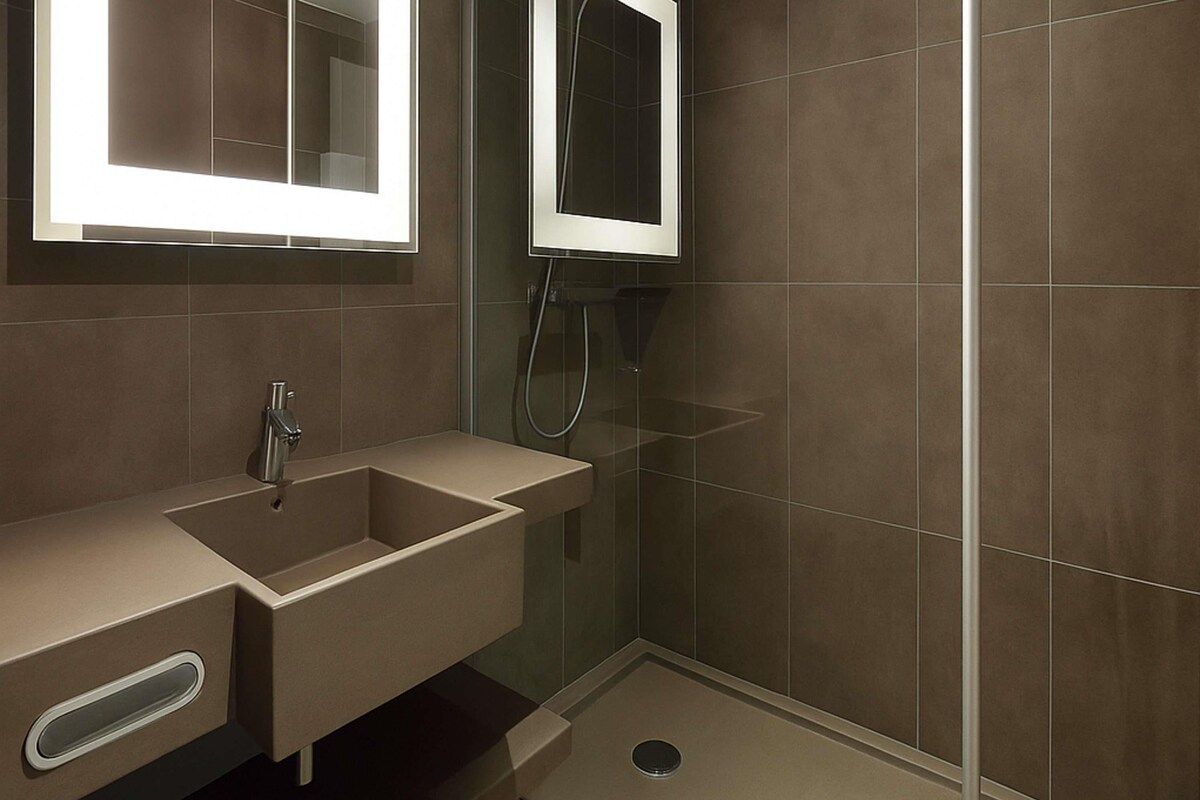 A modern bathroom with a sink, mirror, and shower.