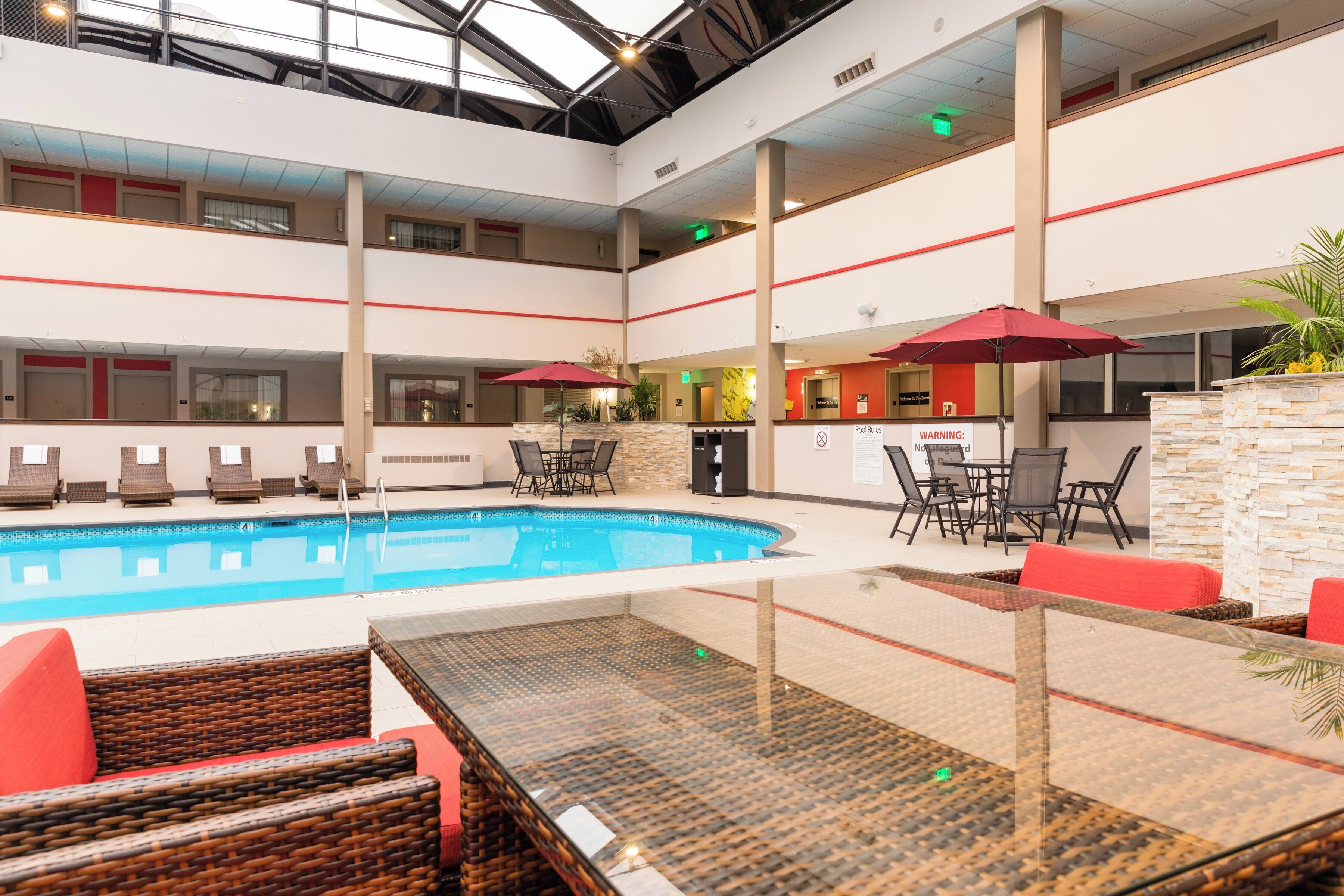 A multi-level indoor swimming pool with lounge areas and a bar.