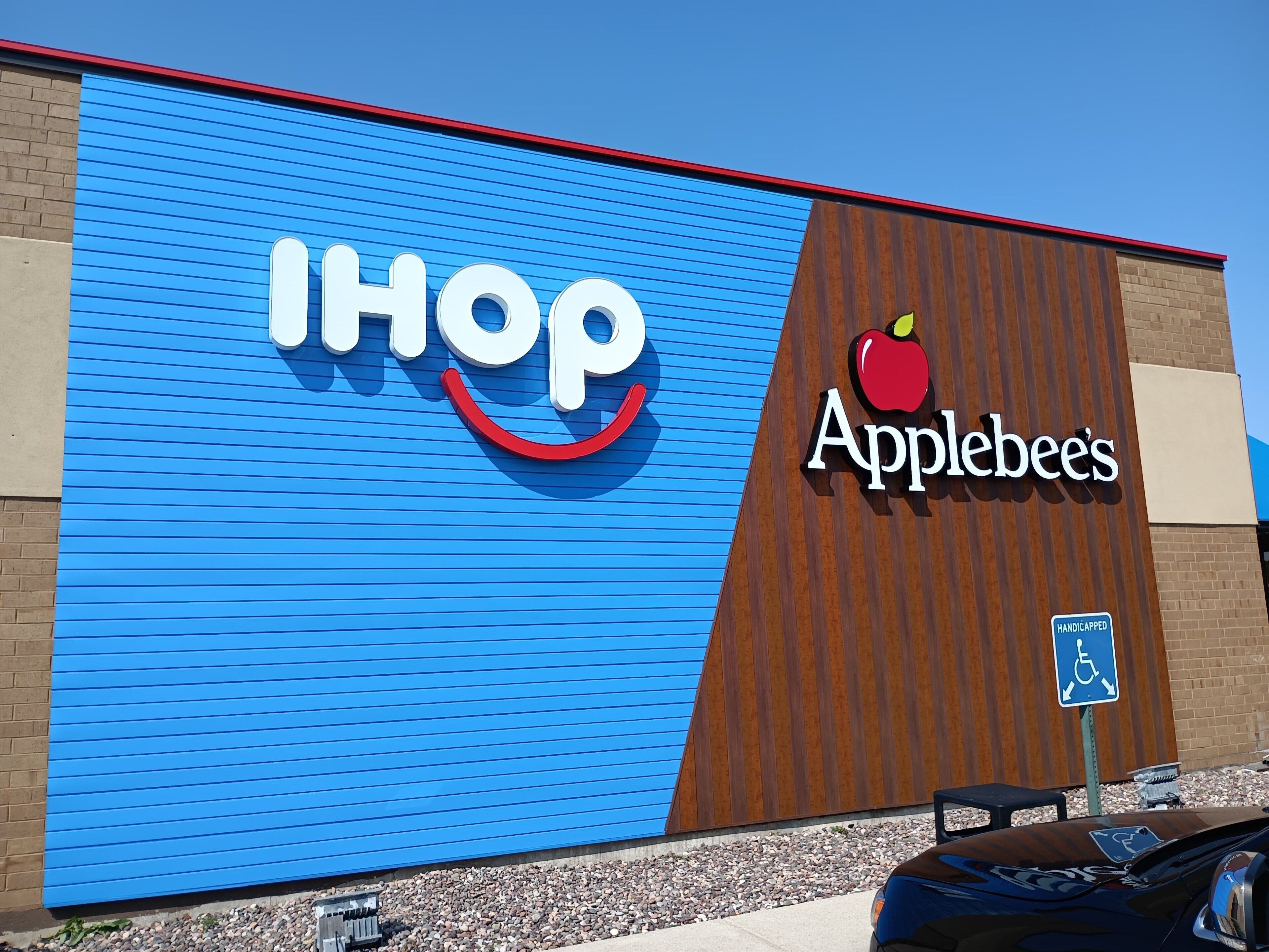 Un edificio con fachada azul y letreros de IHOP y Applebee's.