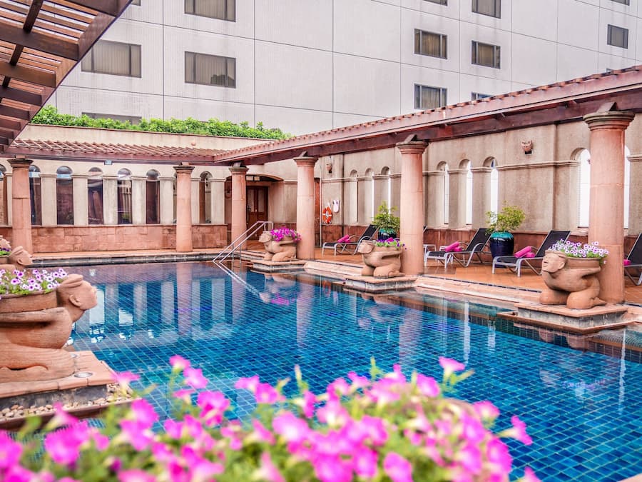 Una piscina al aire libre, tumbonas