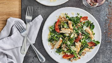 A plate of food with a fork and a napkin on a table.