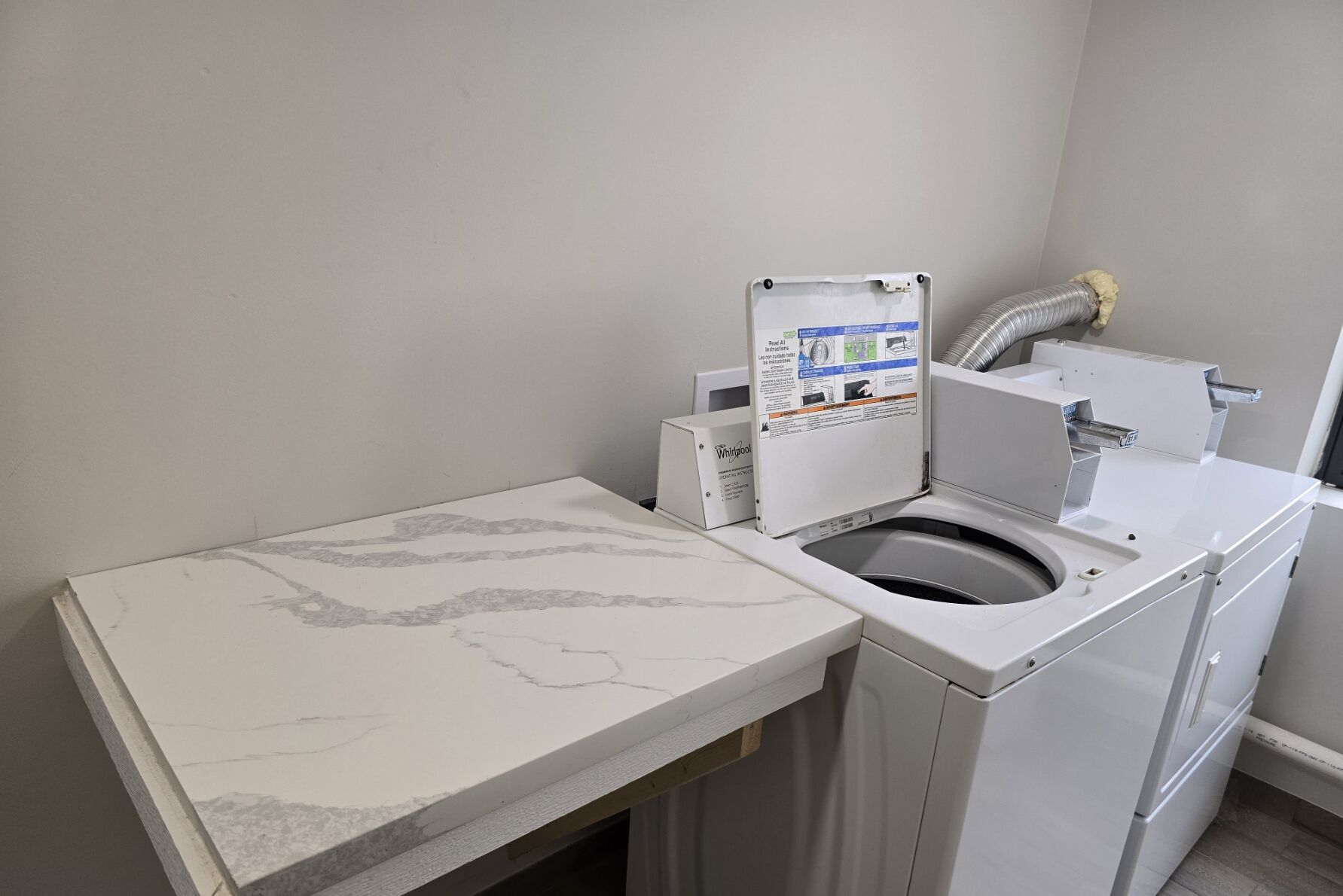 A compact, modern bathroom with a built-in washing machine and a small sink.