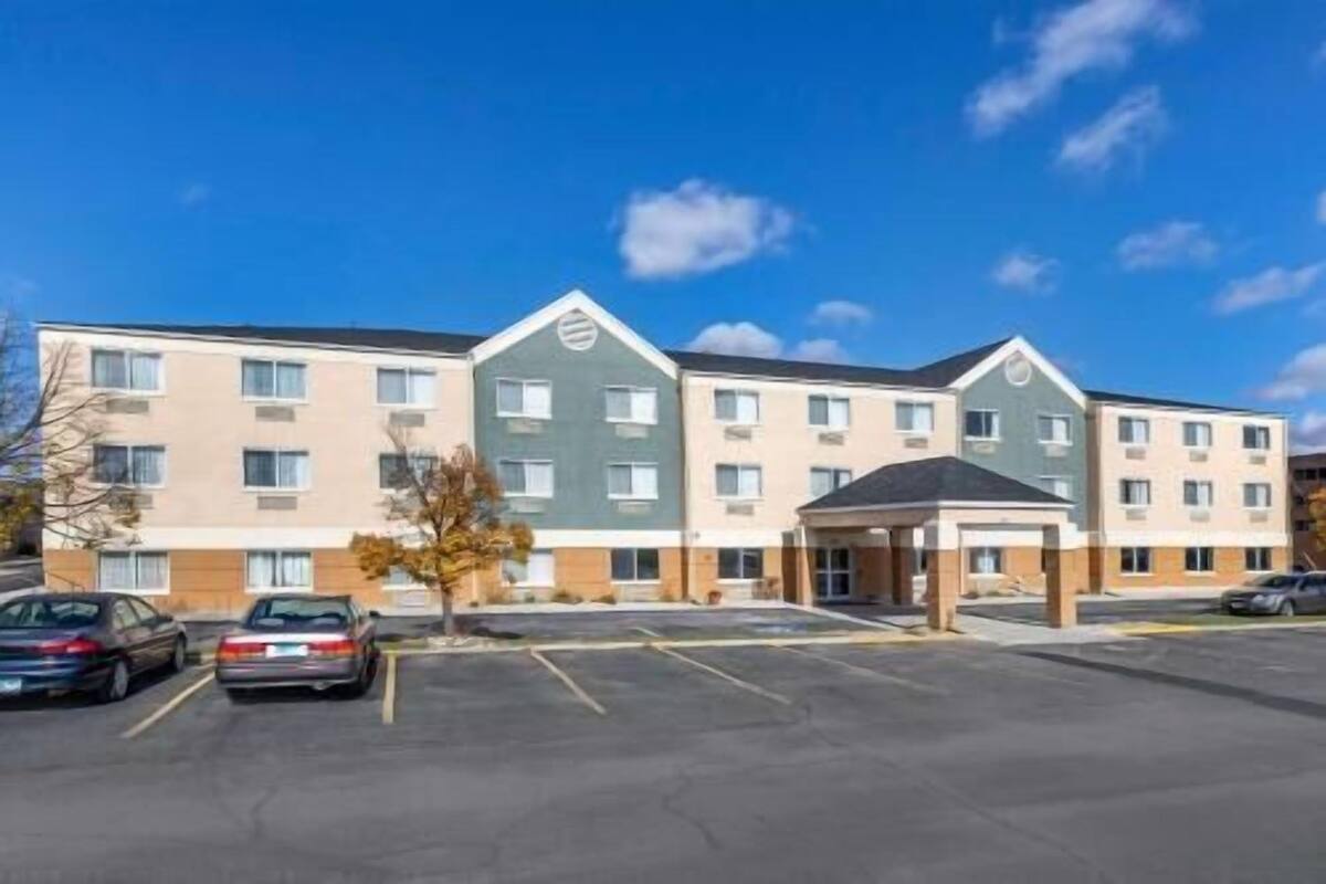 A multi-story hotel with a parking lot in front.