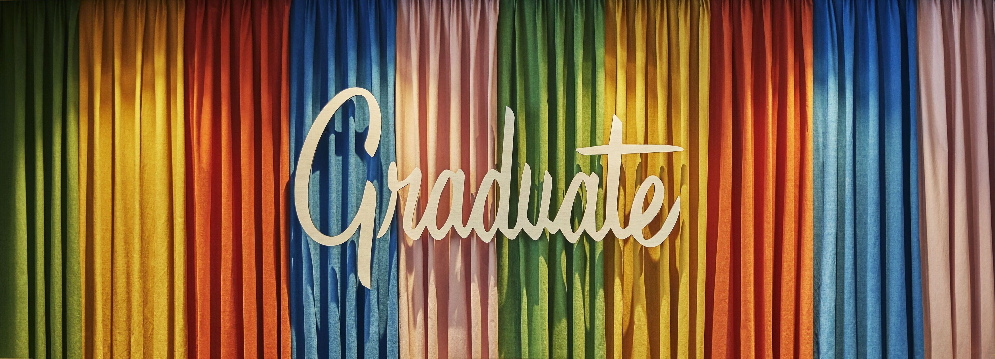 A colorful curtain with the word "Graduate" written on it.