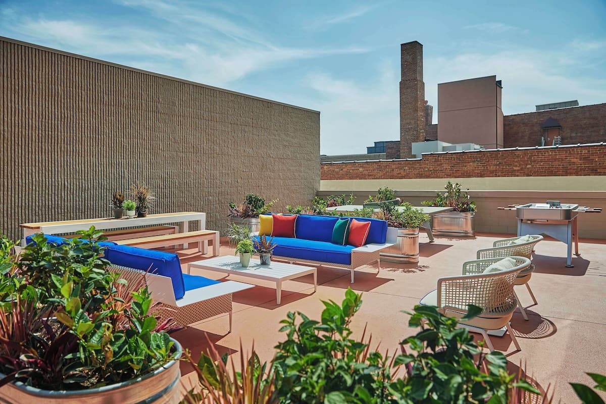 An outdoor patio area with seating, tables, and potted plants.