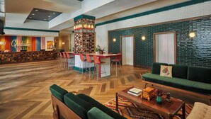 A spacious lobby with a central bar area, seating arrangements, and a decorative wall with a brick pattern. - Graduate by Hilton Lincoln (Lincoln)