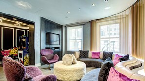 Una sala moderna con un conjunto de sofás, un reposapiés y sillones.