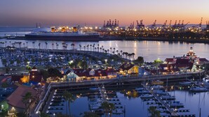A marina with boats docked, a large ship, and industrial cranes in the background. - Hyatt Regency Long Beach (Long Beach)