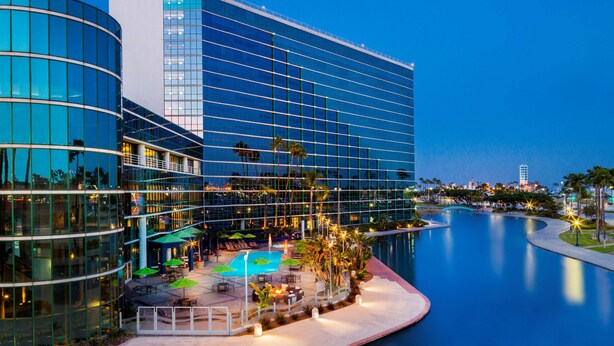 A modern hotel with a pool, outdoor seating, and a waterfront view. - Hyatt Regency Long Beach (Long Beach)