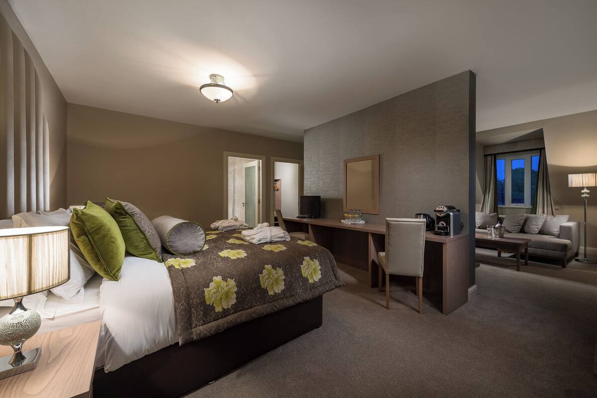 Une chambre d’hôtel comprenant un lit, un bureau et un coin salon.