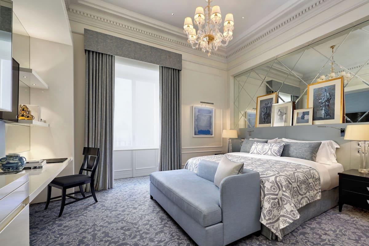 Una habitación de hotel moderna con una cama grande, un escritorio y una silla.