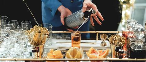 A bar setting with a bartender pouring a drink into a glass.