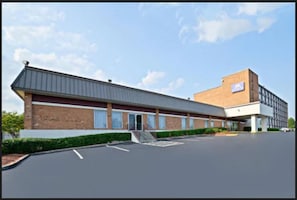 A modern building with a flat roof, large windows, and a brick facade.