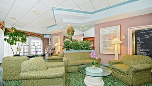 A lobby with patterned sofas, a glass coffee table, and a bulletin board with event information. - Americas Best Value Inn Baltimore (Baltimore)