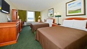 A hotel room with two beds, a desk, a chair, a TV, and a window with curtains. - Americas Best Value Inn Baltimore (Baltimore)