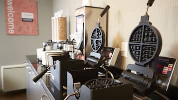 A waffle iron and a waffle maker in a kitchen area.