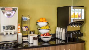 Een koffiehoek met een CITAVO koffiemachine, een schaal fruit en een sapdispenser.