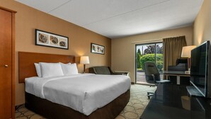 A hotel room with a large bed, a desk with a TV, a chair, and a window with curtains. - Comfort Inn New Glasgow - Stellarton (New Glasgow)
