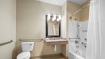 A bathroom with a toilet, sink, mirror, and shower.