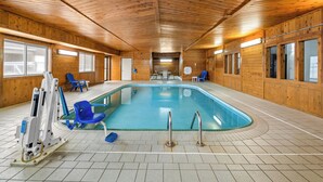 An indoor swimming pool with wooden walls and ceiling, blue chairs, and a water slide. - Quality Inn Dubuque on Hwy 20 (Dubuque)