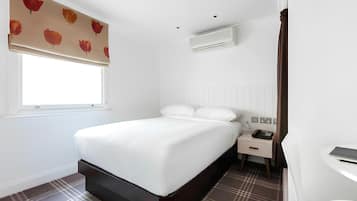 Une chambre d’hôtel moderne avec un grand lit, des tables de chevet, un téléphone sur la table de chevet et une fenêtre donnant sur un beau paysage.
