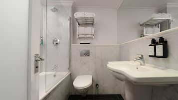 Un baño con ducha, inodoro, lavabo, toallero y espejo.