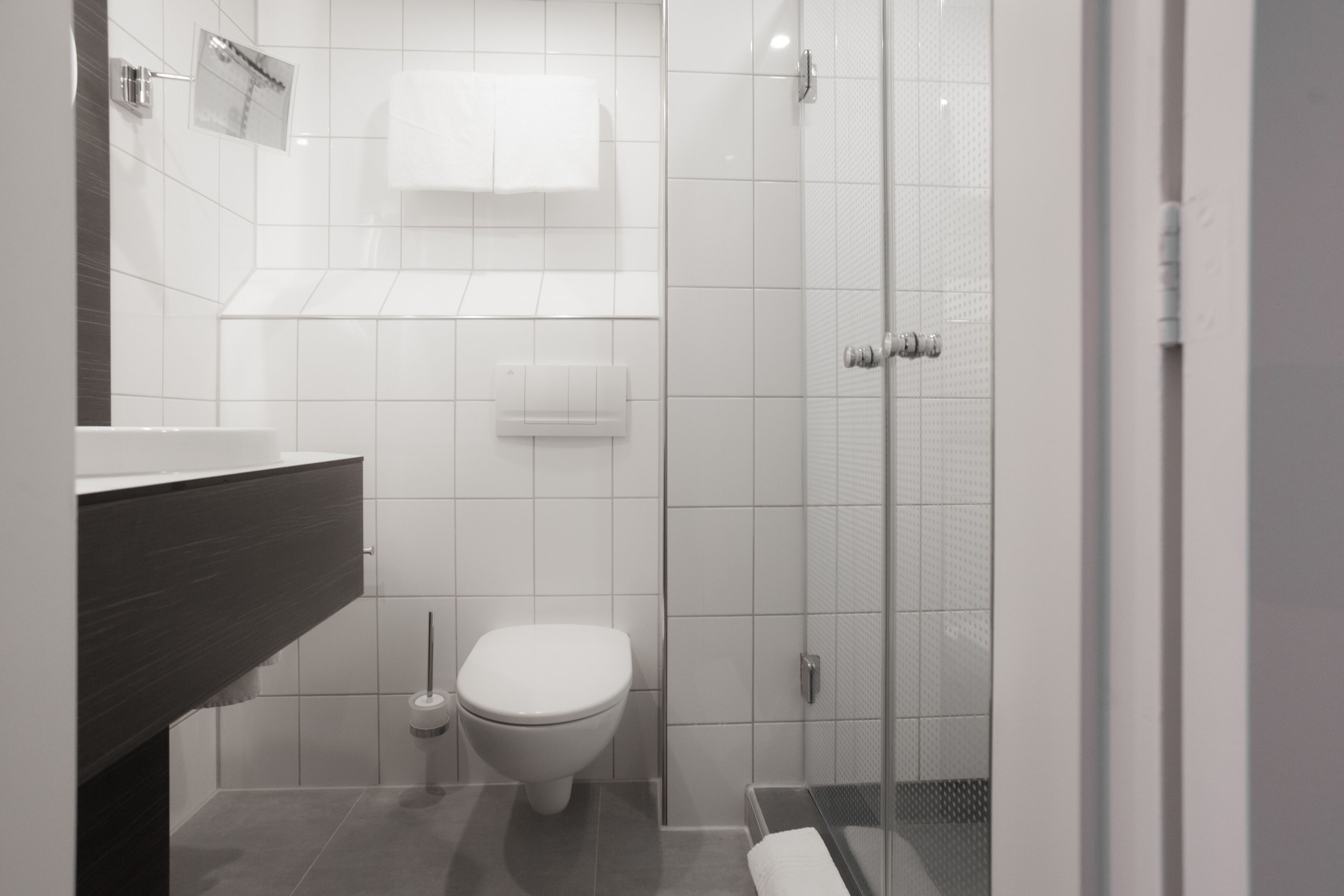 Un baño moderno con inodoro, lavamanos y zona de ducha.