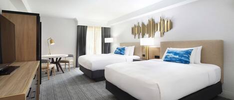 Una habitación de hotel con dos camas, un escritorio y un comedor.