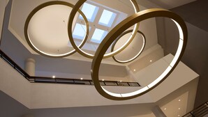 Un interior moderno con un aplique circular y vistas al cielo a través de un tragaluz.